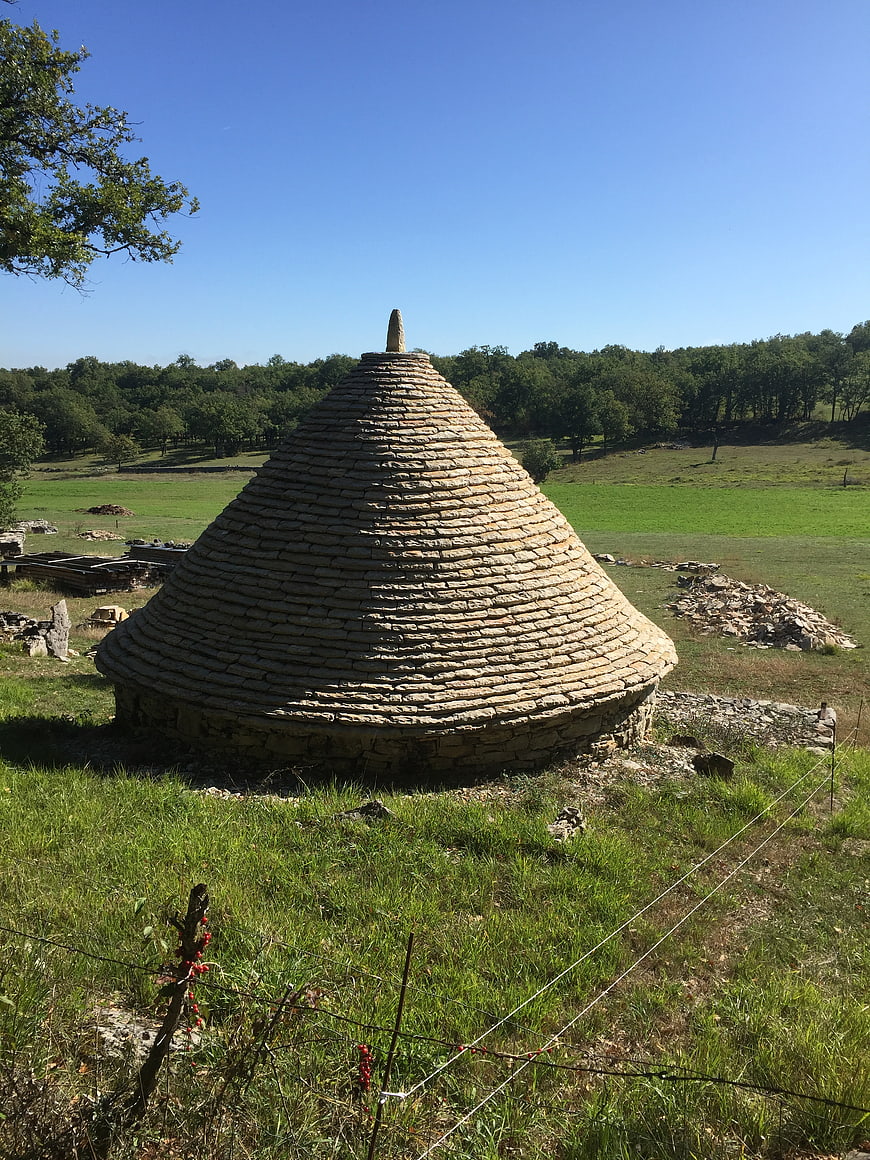 Ancient stone beehive hut in green countryside