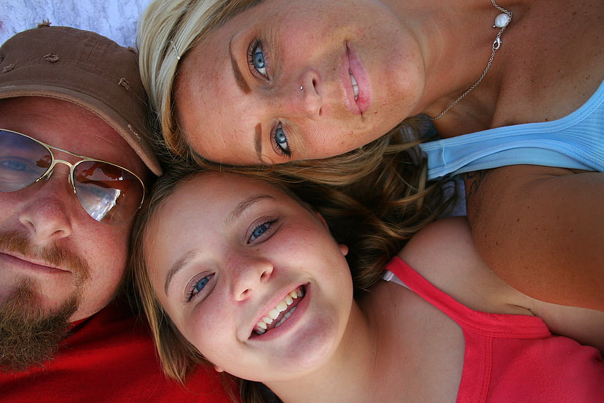 Happy family lying down looking up at camera