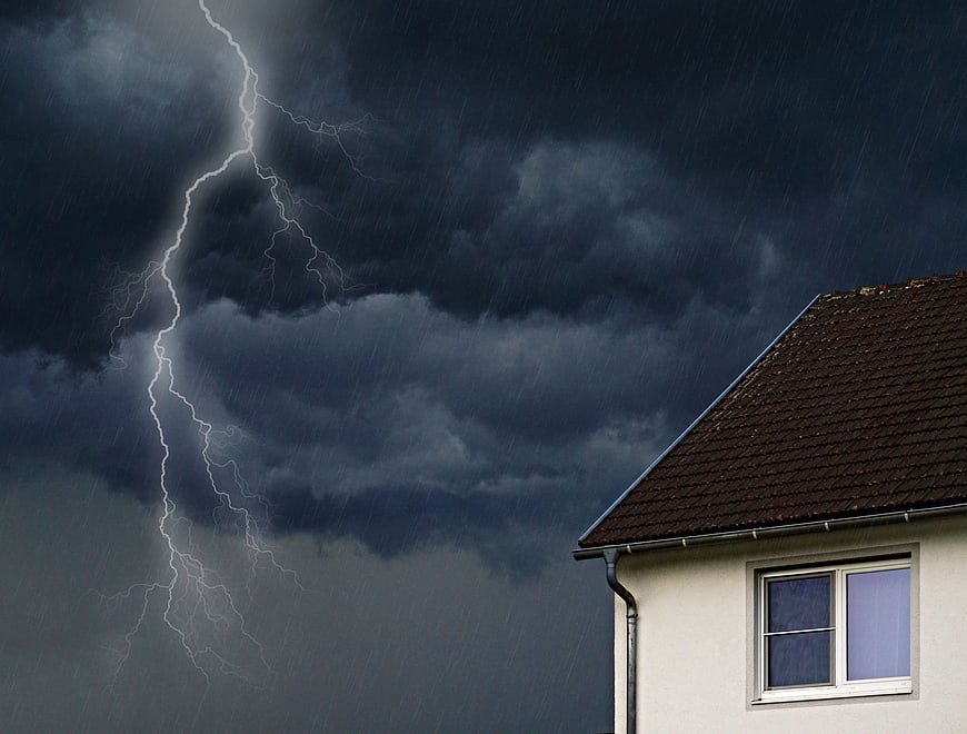 Dramatic lightning strike over residential house during thunderstorm