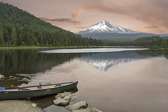 Canoe on Lake Shore with Snow-Capped Mountain Reflection