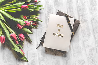 Pink tulips and motivational notebook on white background