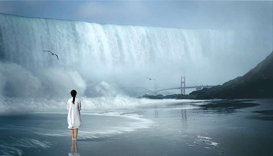 Woman standing on beach facing massive tsunami wave and bridge