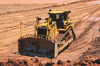 Yellow Caterpillar Bulldozer Working on Red Dirt Construction Site