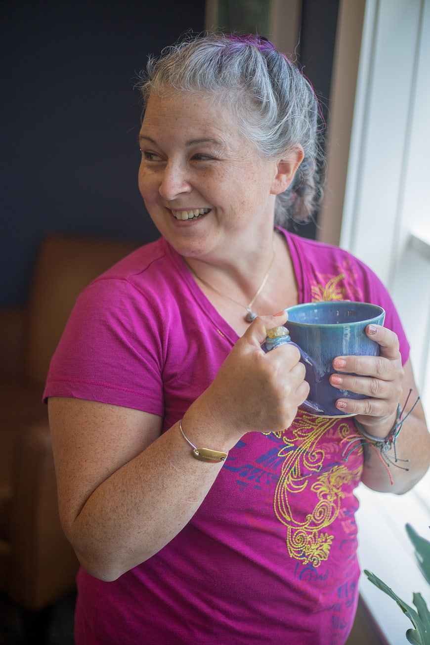 Happy Senior Woman Drinking Coffee by Window
