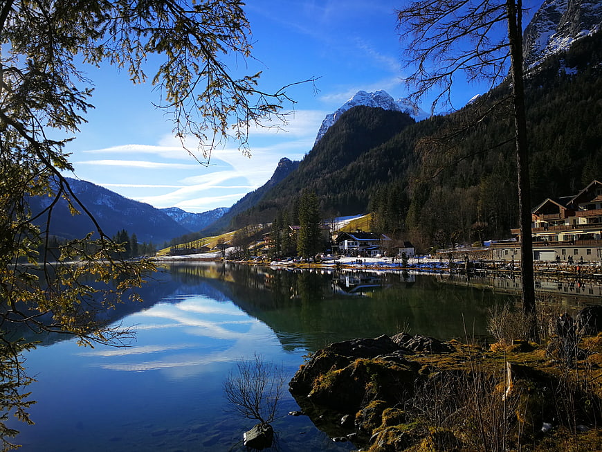 Serene Alpine Lake with Mountain Reflections and Village