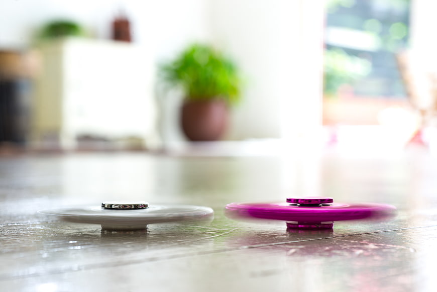 Spinning fidget spinners on a wooden table surface