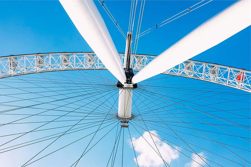 Low angle view of white wind turbine blades against blue sky