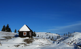 Rustic wooden cabin in snowy winter mountain landscape