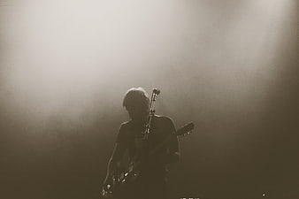 Silhouette of Guitarist Performing on Smoky Stage