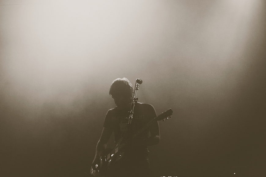 Silhouette of Guitarist Performing on Smoky Stage