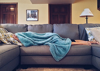 Person Sleeping on Sofa Under Teal Blanket
