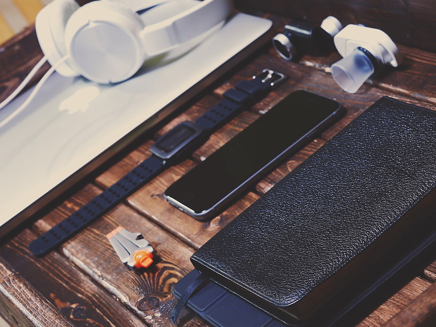 Flat lay of tech gadgets and accessories on wooden table