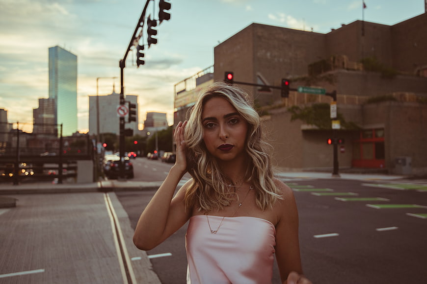 Blonde Woman in Pink Top on Urban Street at Sunset