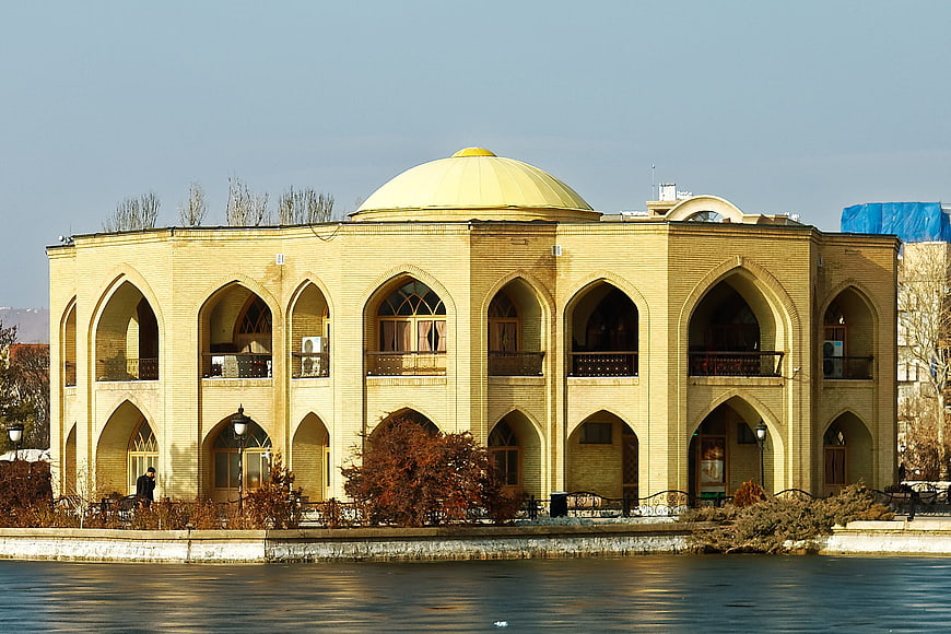 Traditional Iranian Architecture with Golden Dome by Lake