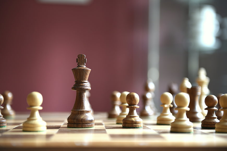 Close-up of wooden chess pieces on a board with blurred background