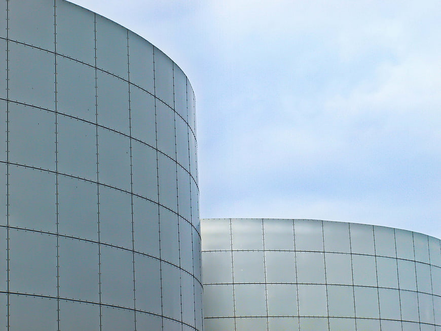 Modern curved glass building facade against blue sky