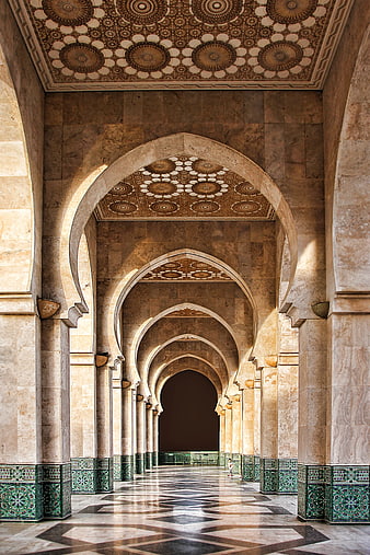 Ornate Moorish arches and tiled ceilings in a grand museum corridor