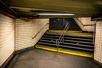 Empty Subway Staircase With White Tiled Walls And Yellow Safety Edges
