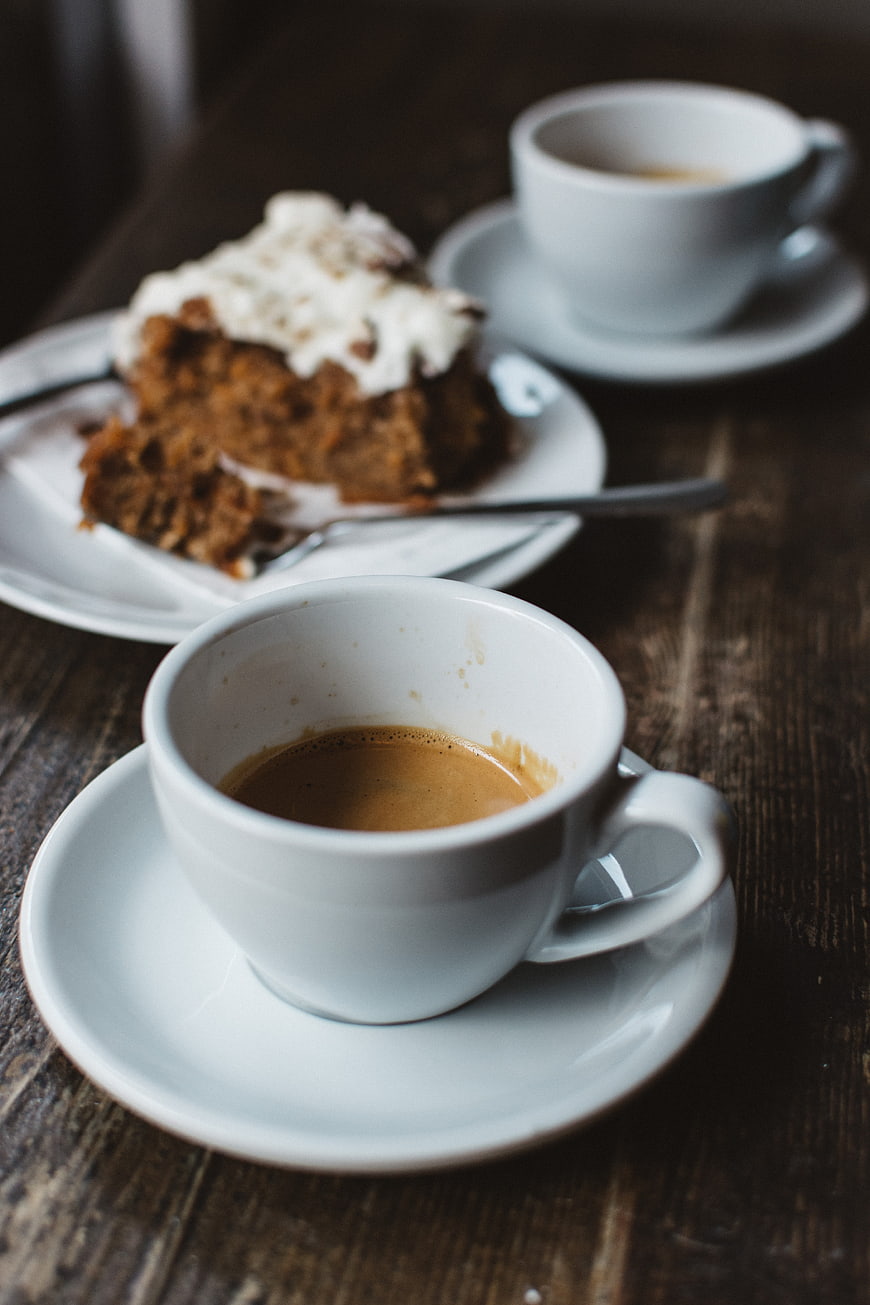 Espresso coffee and frosted cake on rustic wooden table