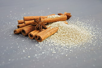 Cinnamon sticks and star anise with vanilla sugar on gray background