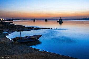 Serene Long Exposure Fishing Boat at Sunset on Calm Sea