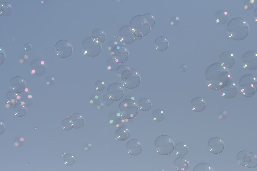 Abstract Soap Bubbles Floating Against Soft Blue Background