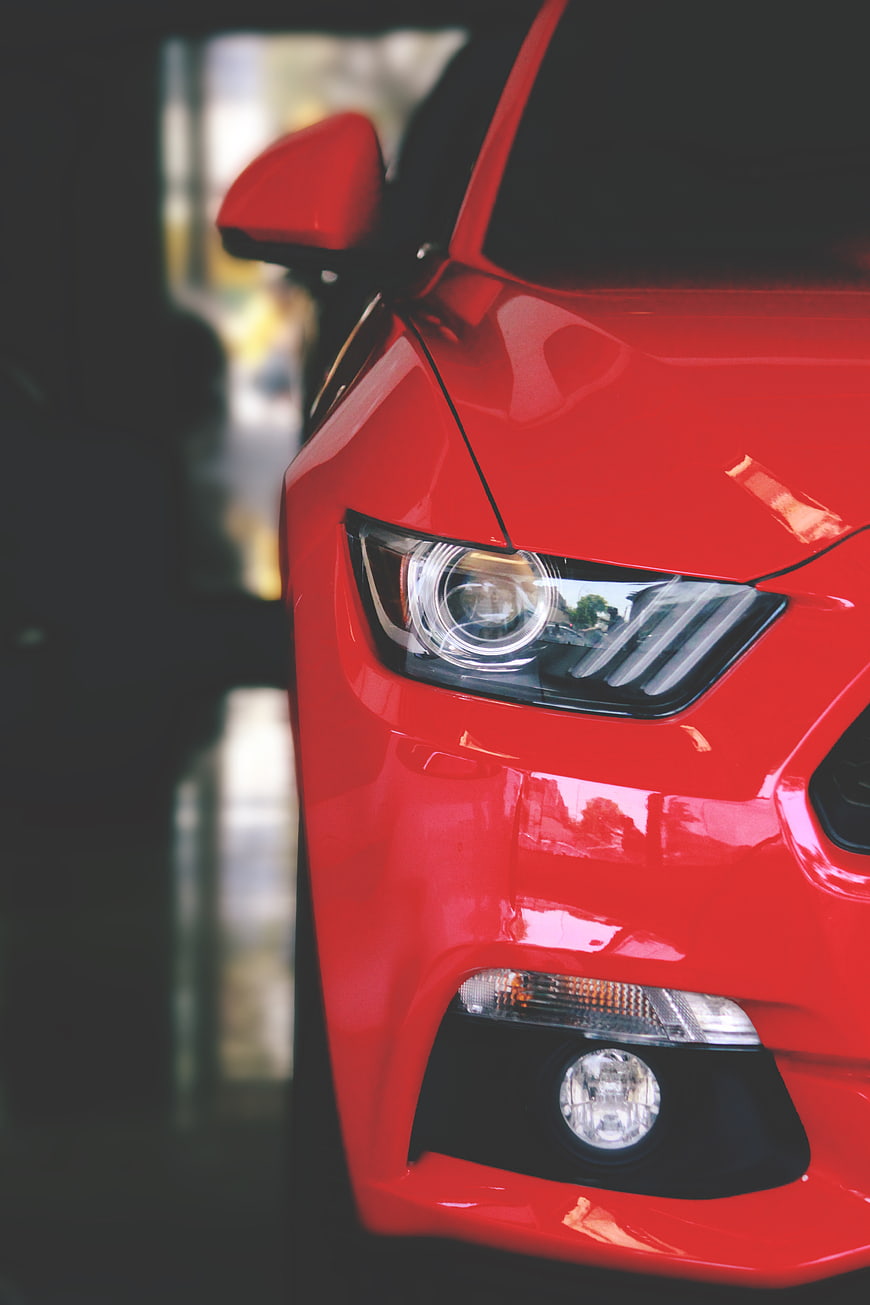 Close-up of Red Car Headlight and Front Bumper Detail