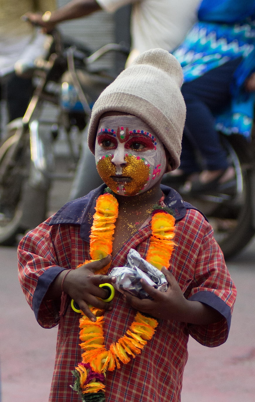 Child with Face Paint and Flower Garland at Festival