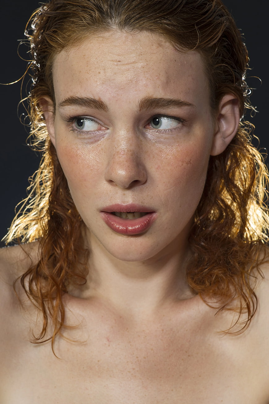 Close-up portrait of woman with wet curly red hair