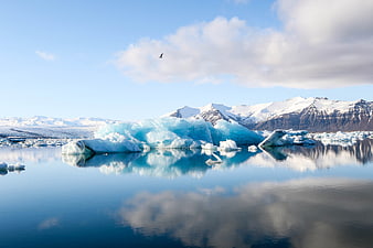 Stunning Blue Icebergs Floating in Calm Glacial Lagoon with Mountain Reflections