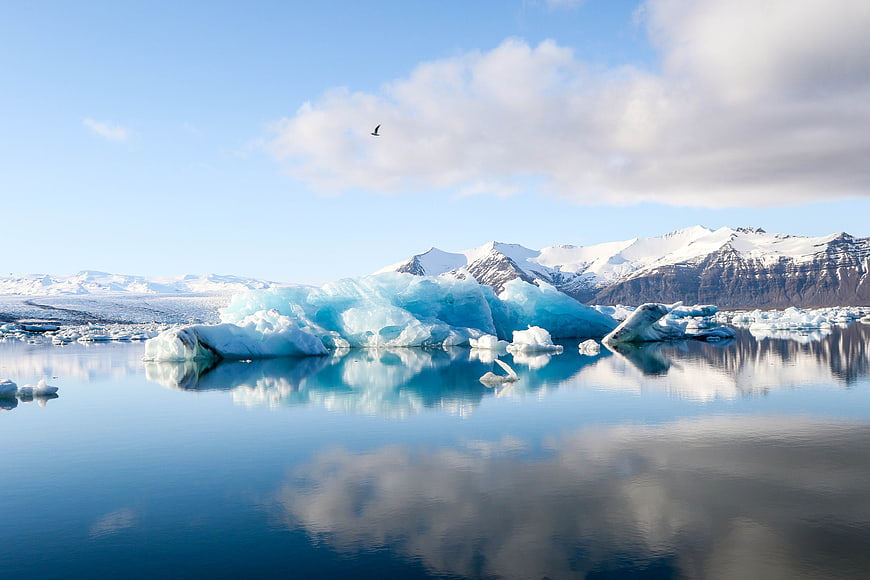 Stunning Blue Icebergs Floating in Calm Glacial Lagoon with Mountain Reflections