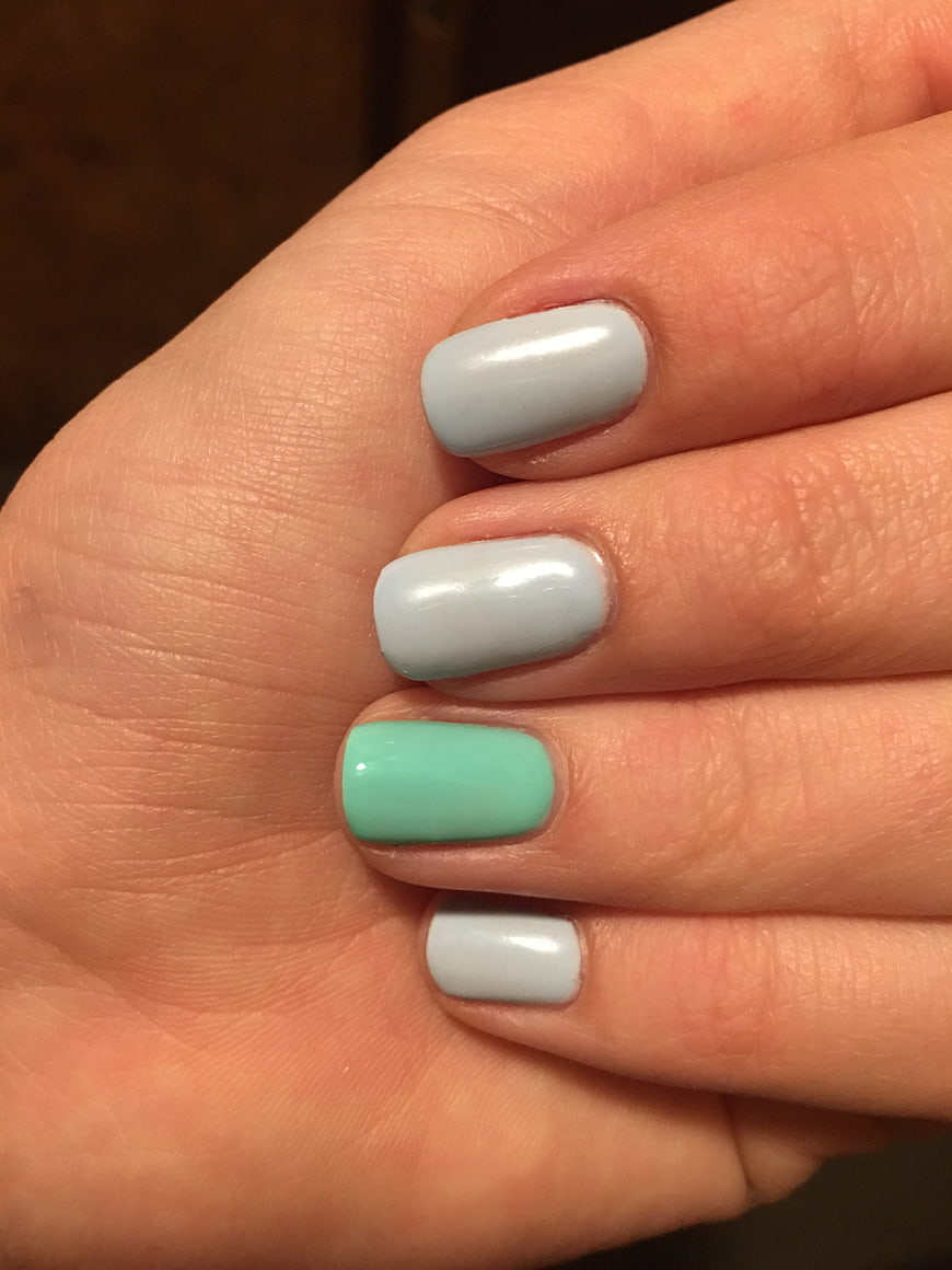 Close-up of hand with mint and grey manicure