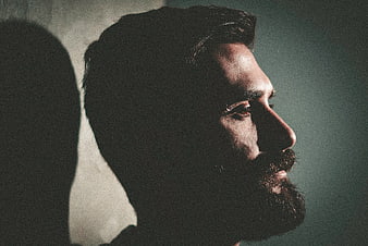 Dramatic profile portrait of bearded man in shadow