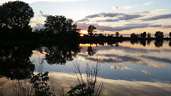 Serene Lake Sunset with Tree Reflections and Golden Sky