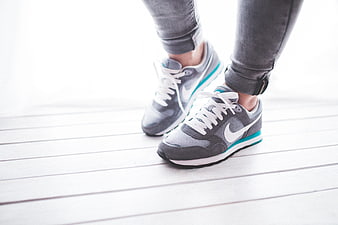 Close-up of grey Nike sneakers on white wooden floor