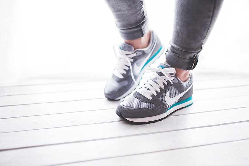 Close-up of grey Nike sneakers on white wooden floor