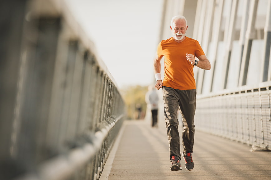 Senior man jogging on bridge