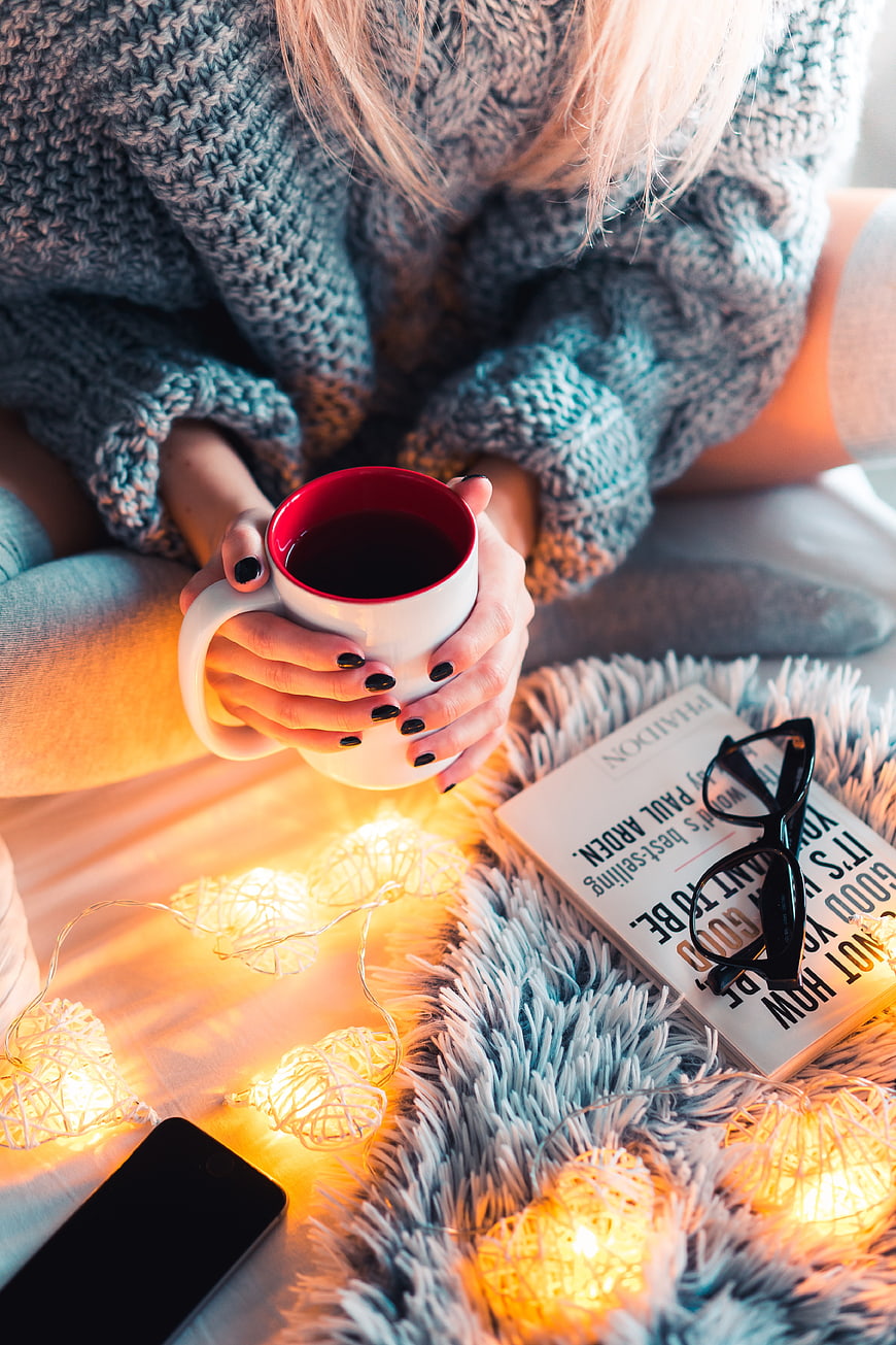 Cozy winter reading with hot tea and fairy lights
