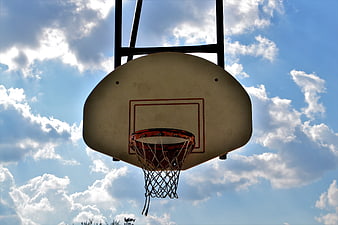 Outdoor Basketball Hoop Against Blue Sky with Clouds