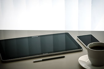 Samsung tablet, smartphone, and coffee cup on a desk