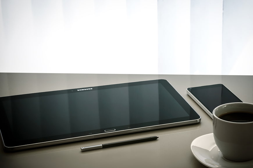 Samsung tablet, smartphone, and coffee cup on a desk