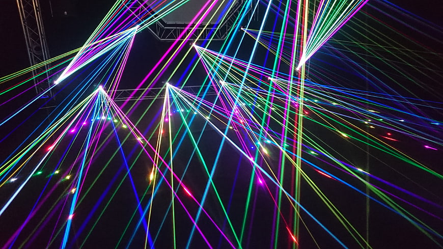 Colorful laser light show beams at night concert