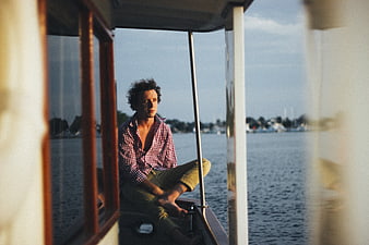 Man sitting on boat looking out over water