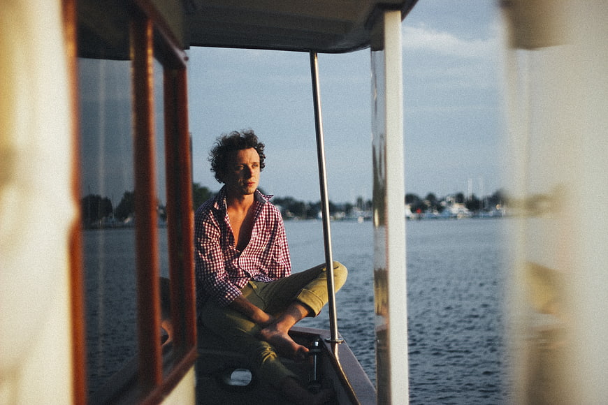 Man sitting on boat looking out over water