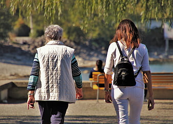 Senior Woman And Young Woman Walking Together In Park