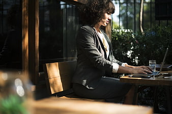 Professional Woman Working on Laptop at Outdoor Cafe
