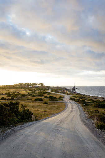 Winding Coastal Road Leading to Windmill at Sunset