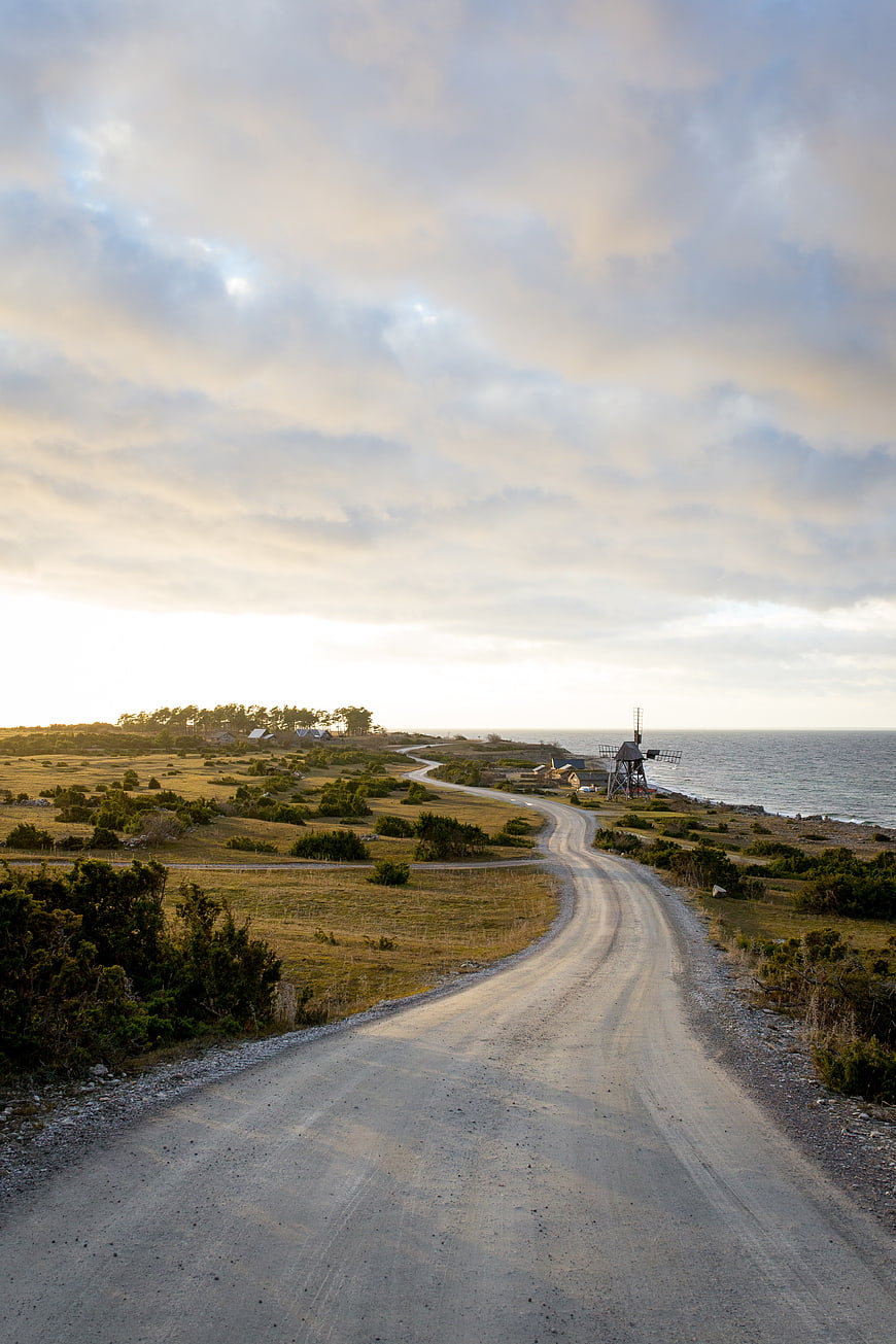 Winding Coastal Road Leading to Windmill at Sunset