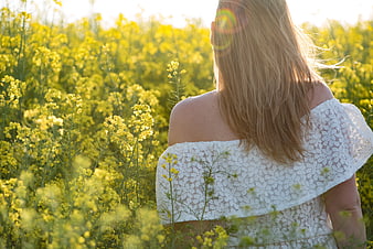Woman in White Lace Dress Standing in Yellow Flower Field