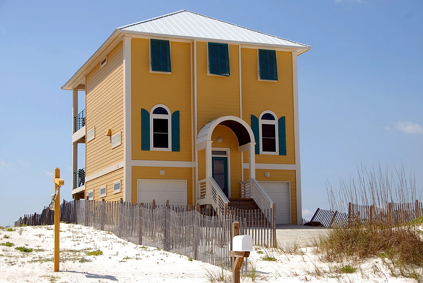 Yellow Beach House with Blue Shutters on Sand Dunes